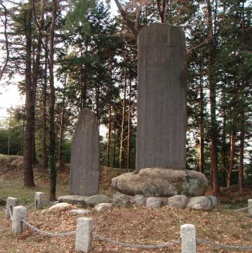 石と鎖で仕切れた一角に大小2つの石碑が置かれいてる仙覚律師遺跡の写真