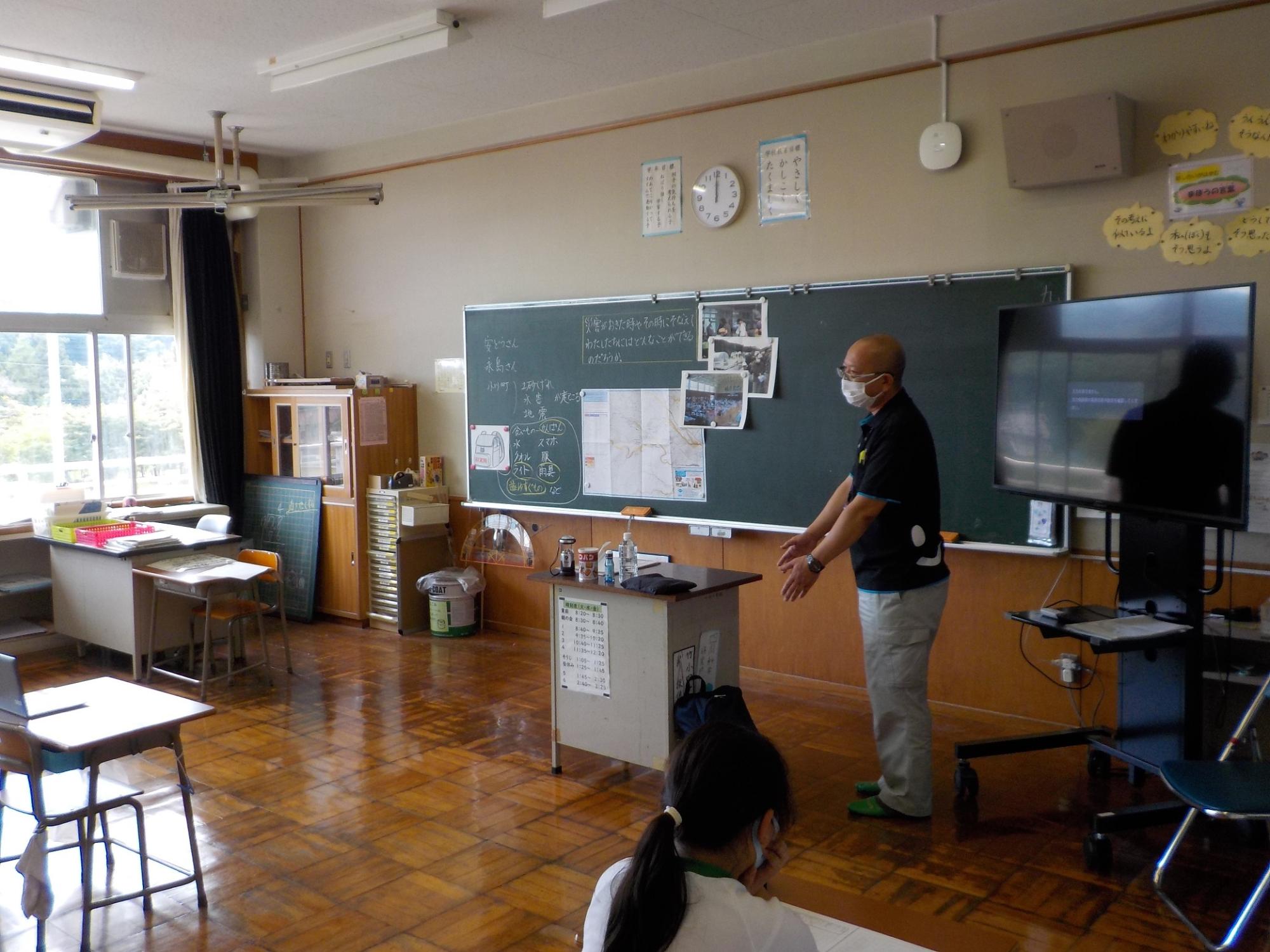 男性が教室の前の方に立って話をしている写真