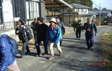 参加者たちが住宅地の中の道路を歩いている写真