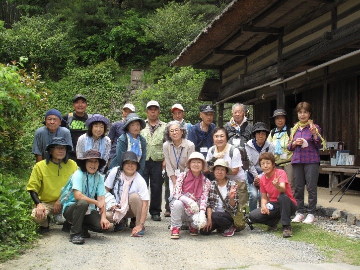 参加者たちが吉田家住宅の家の前の庭に並んでいる集合写真