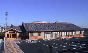 瓦の三角屋根で入口前に駐車スペースが設置されているふれあいプラザおがわ外観写真