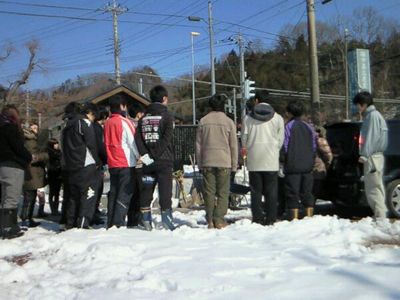 除雪活動の支援隊の方々が並んで立っている後姿を撮影した写真