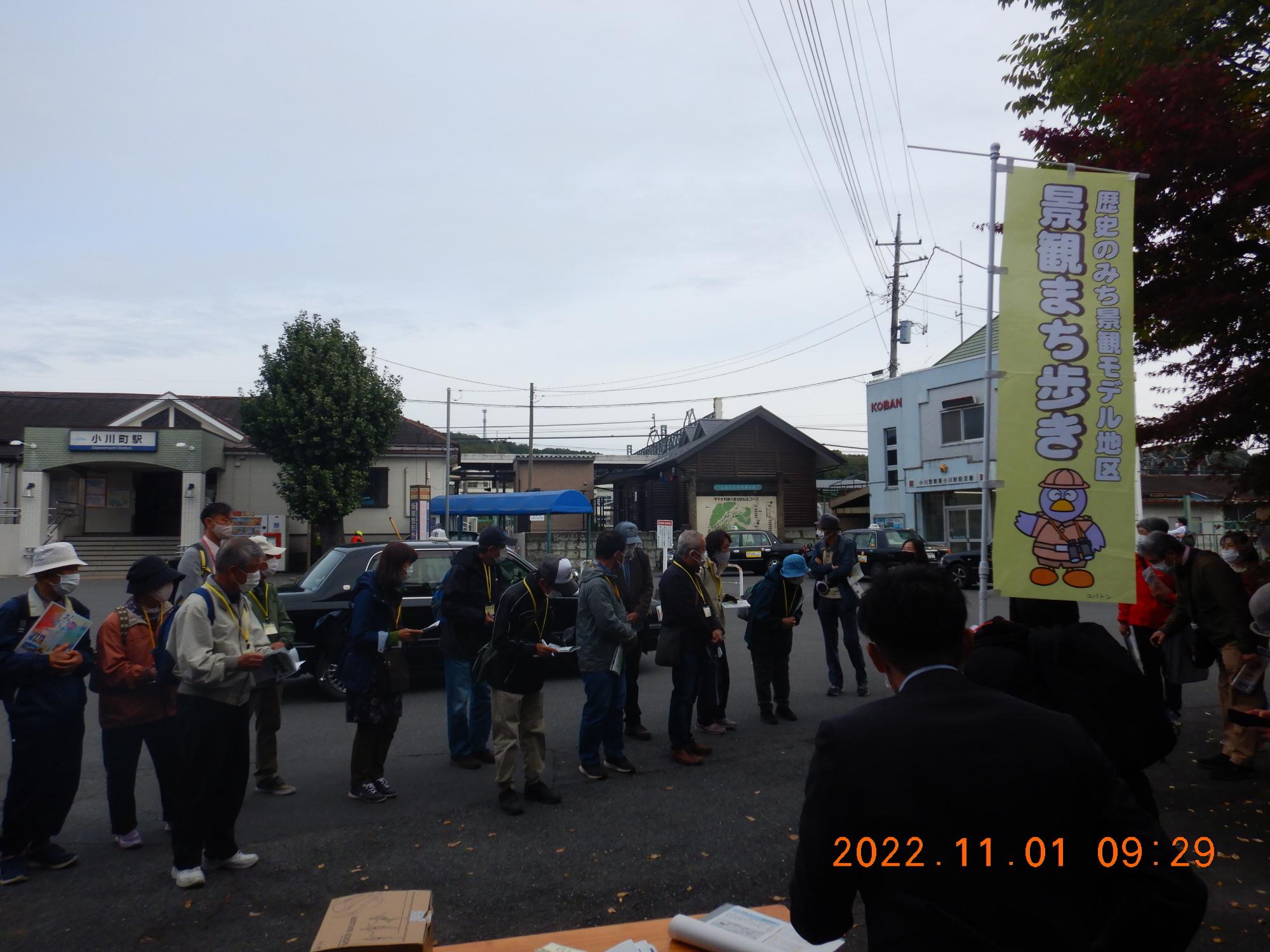 「景観まち歩き」と書かれたのぼり旗が立っている場所に、参加者達が横に広がり並んでいる写真