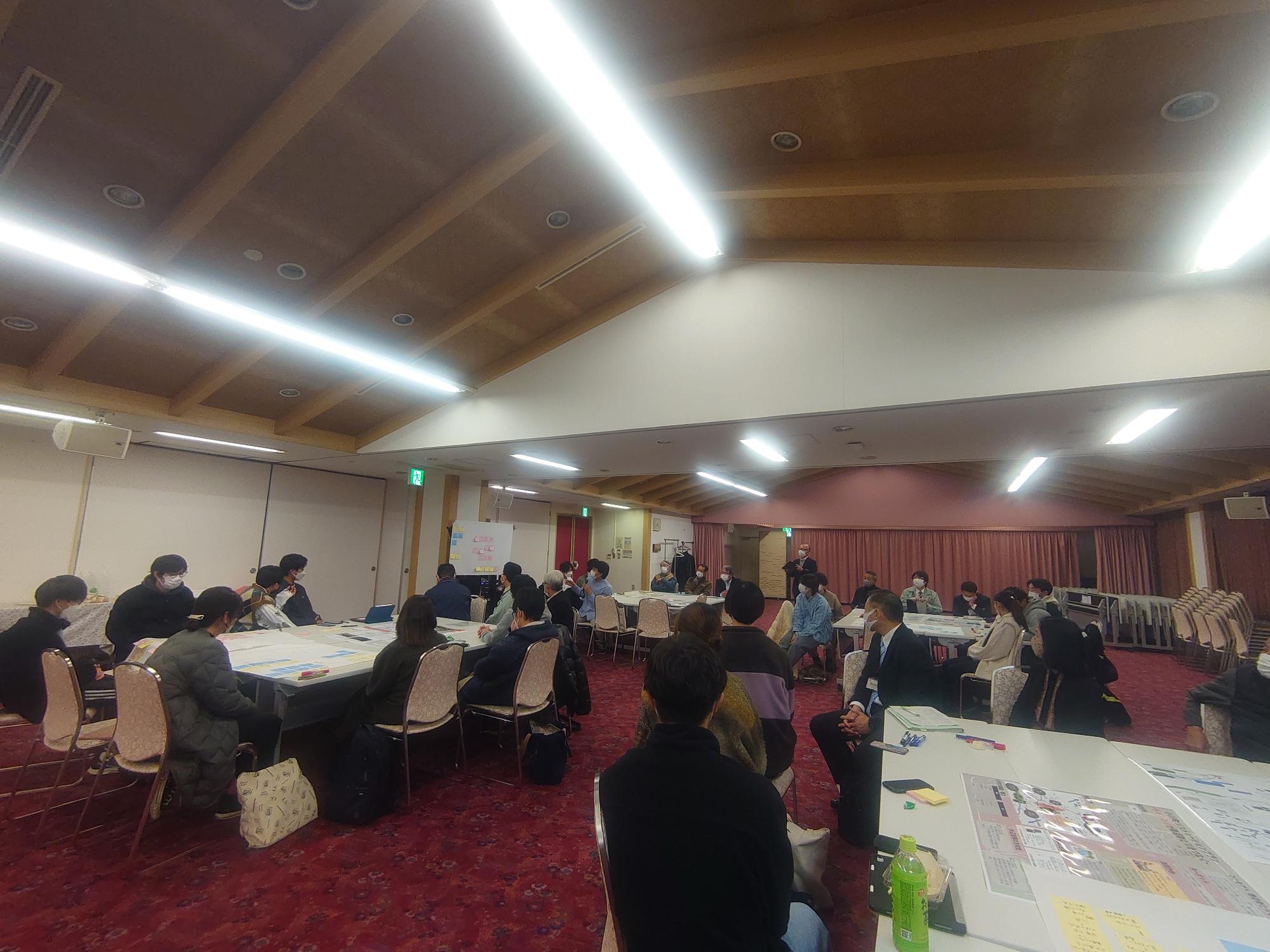 室内の電灯が3本の線になり光っている意見発表会の会場の様子を写した写真