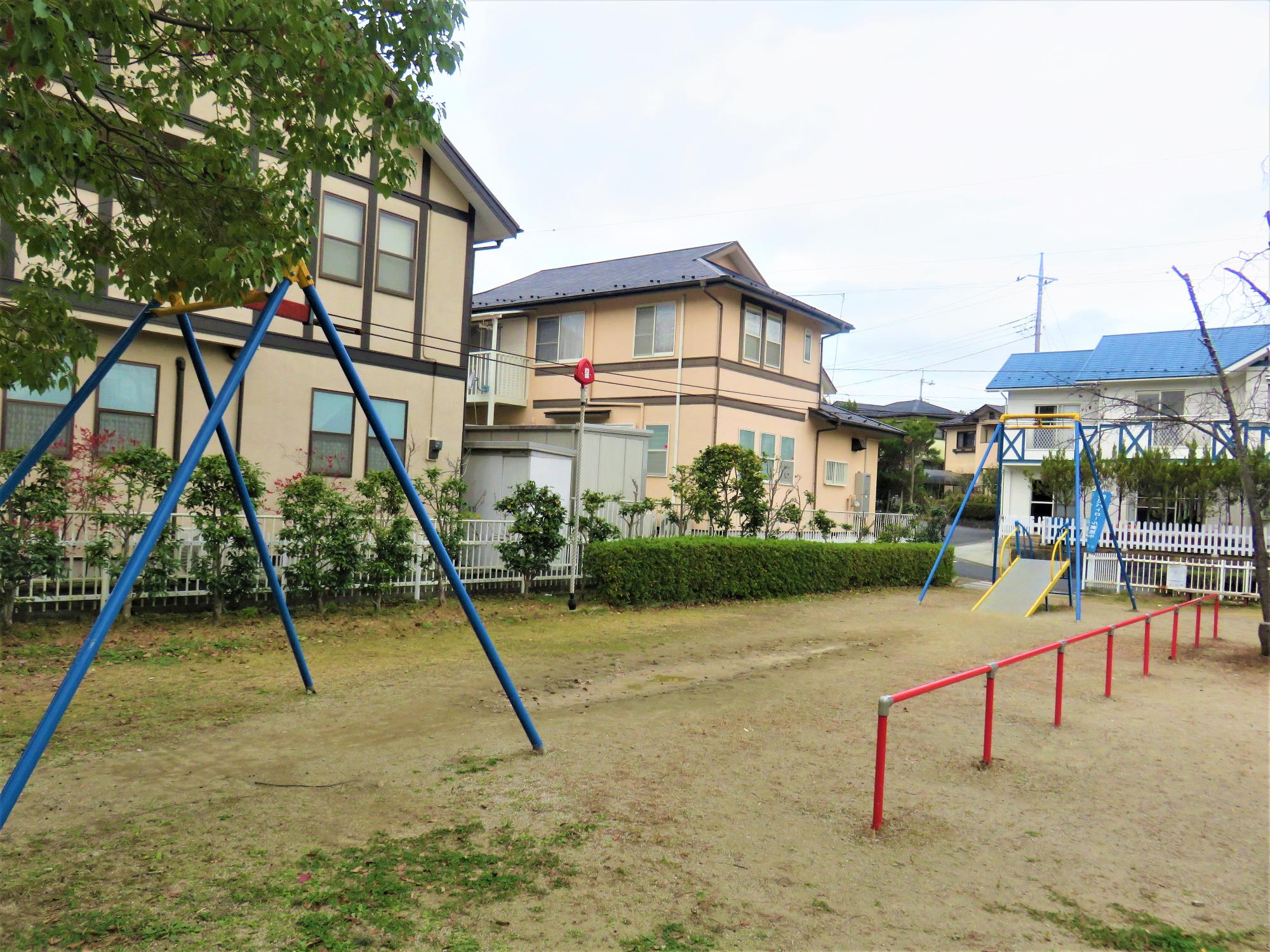 背の低い赤い柵で仕切られた奥に設置されているターザンロープの写真