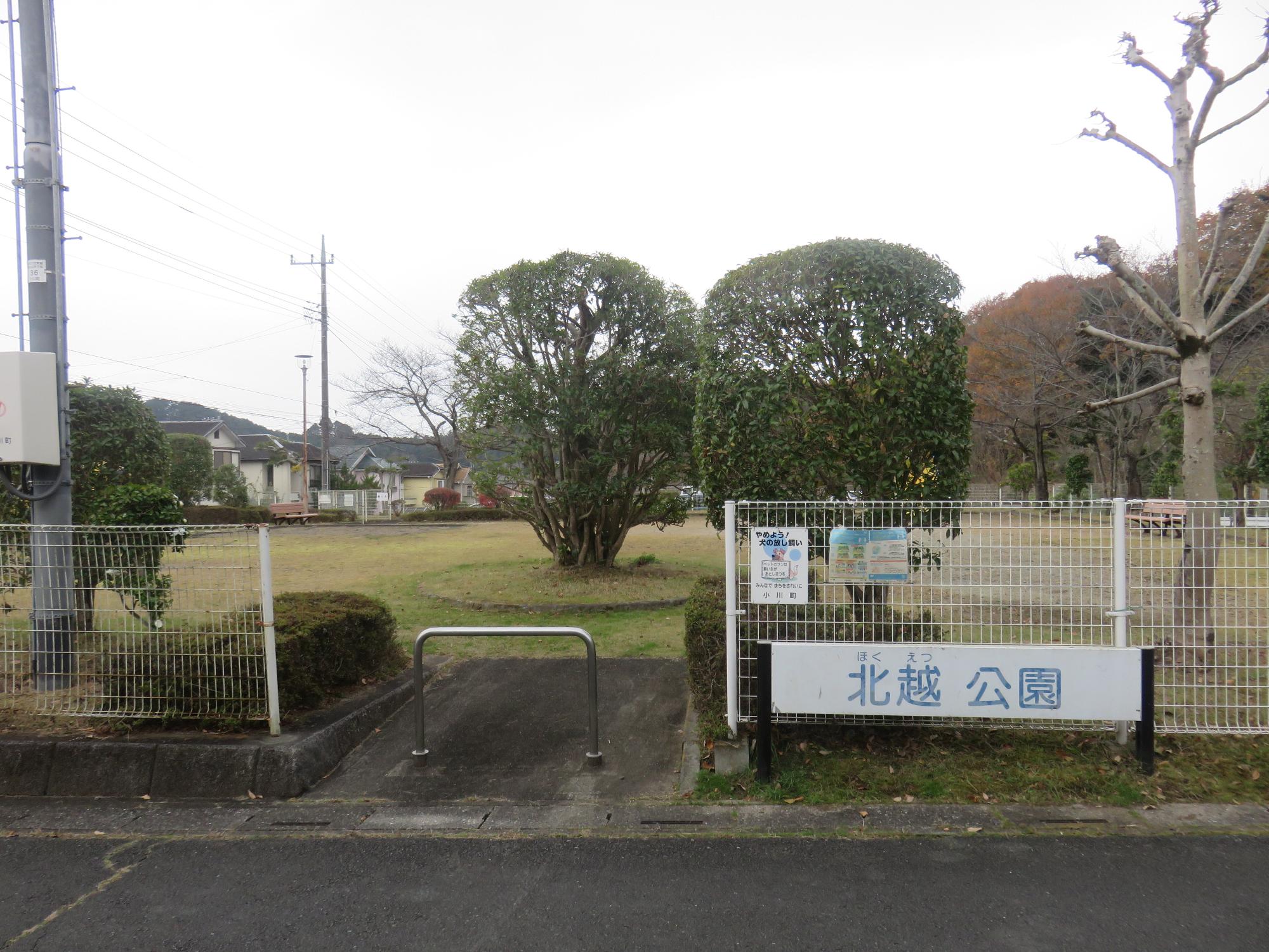 白いフェンスや木々に囲まれた敷地内に手入れされた生垣やベンチが設置されたみどりが丘北越公園の写真