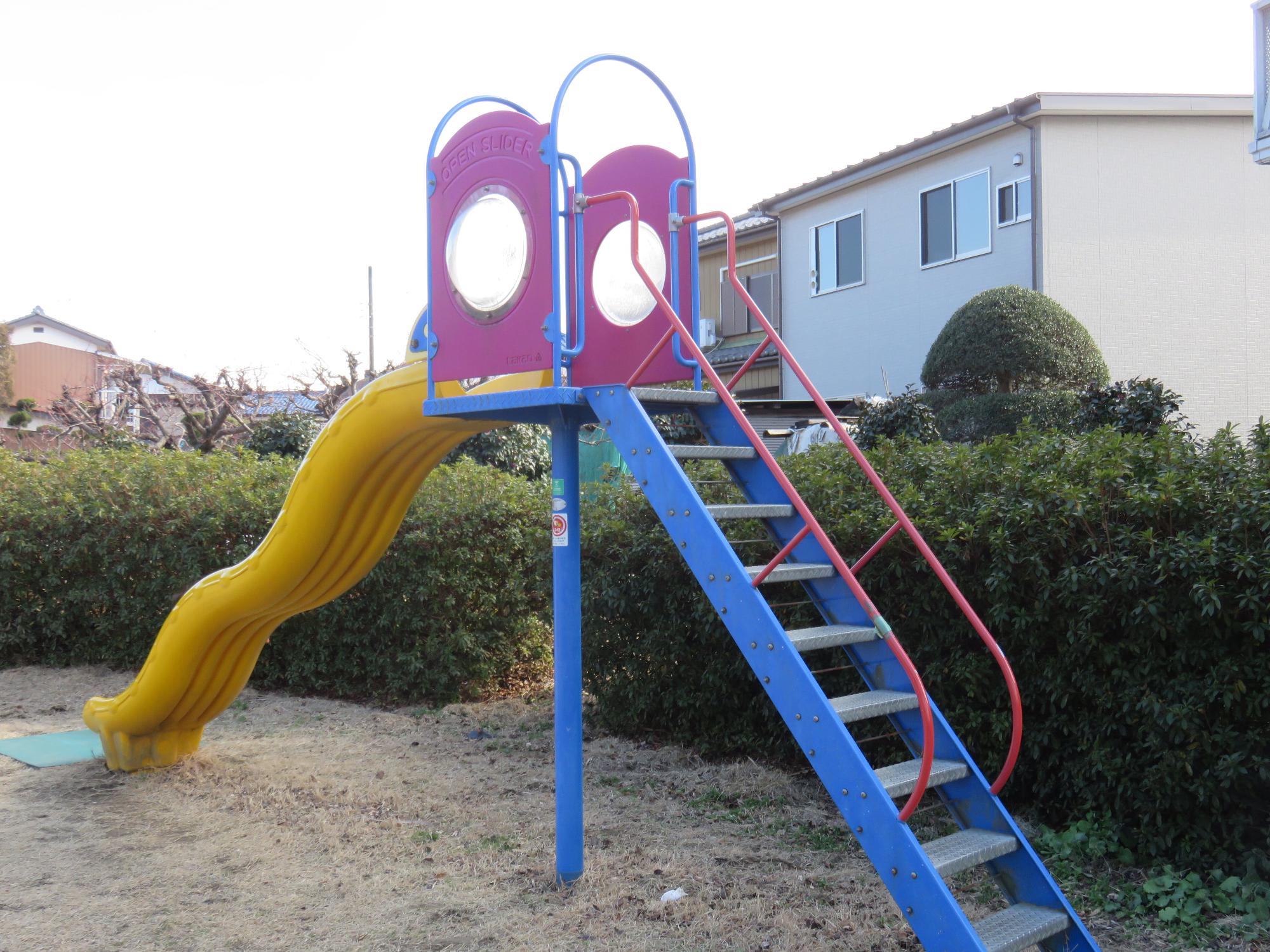 階段部分が青色、滑り台部分が黄色の滑り台を写した写真