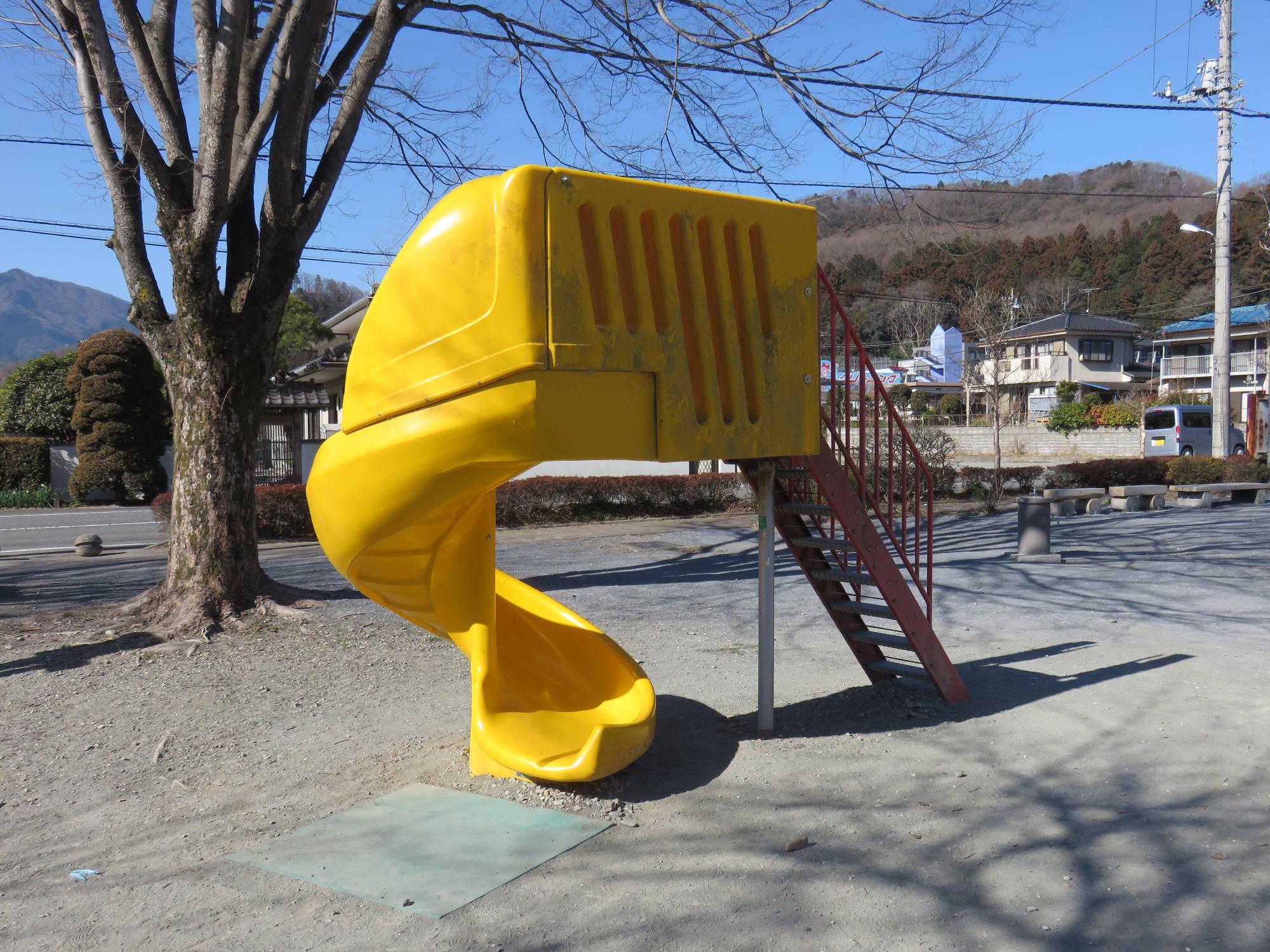 滑る部分が螺旋状になっている黄色い滑り台の写真