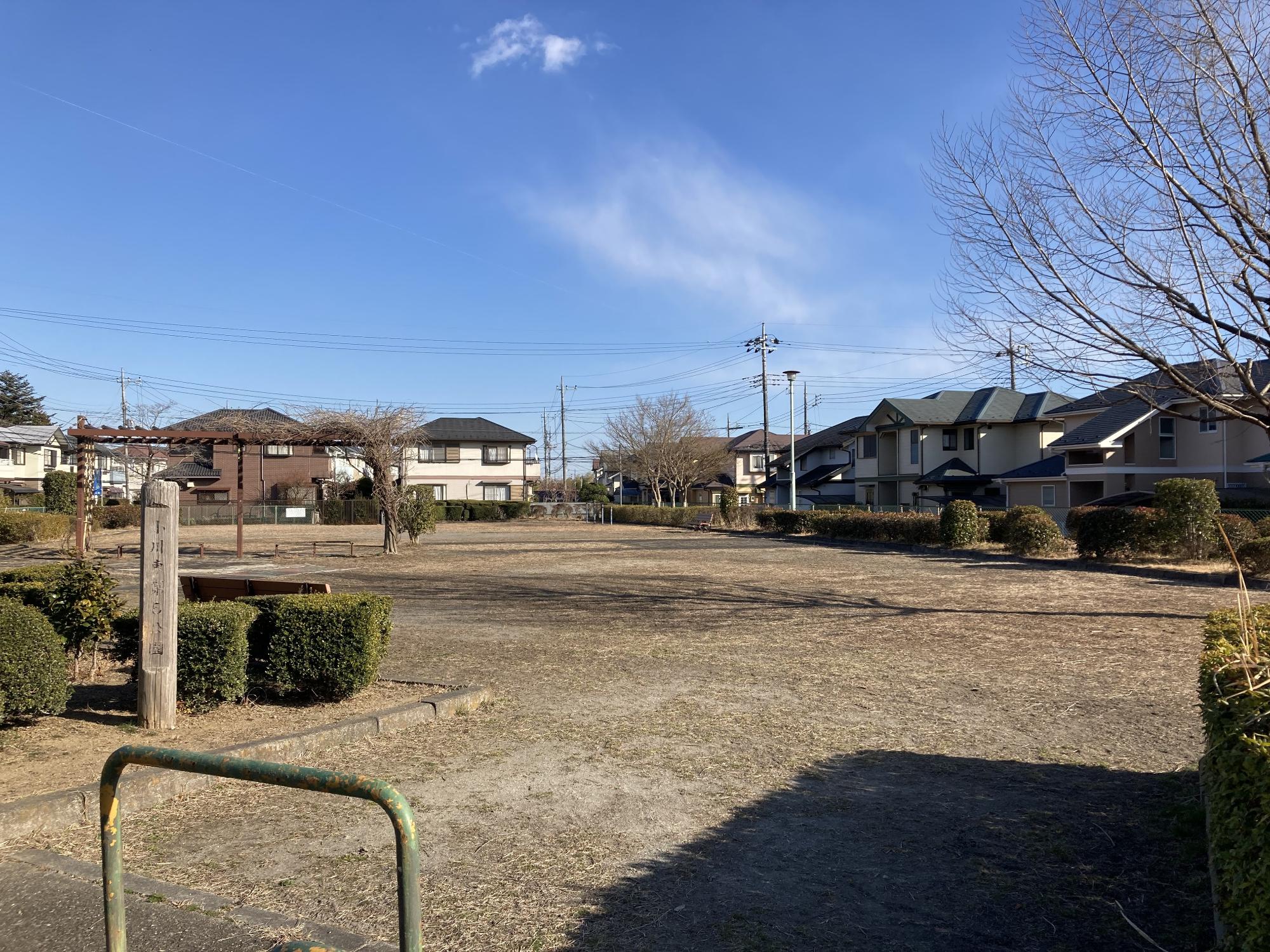 住宅街の中にあり生垣に囲まれた公園内に、ベンチやパーゴラが設置された小川東第5公園の写真
