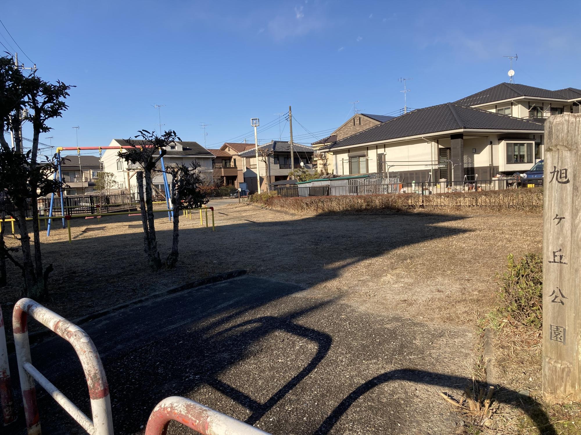 住宅街に隣接した敷地内にブランコが設置された旭ヶ丘公園の写真