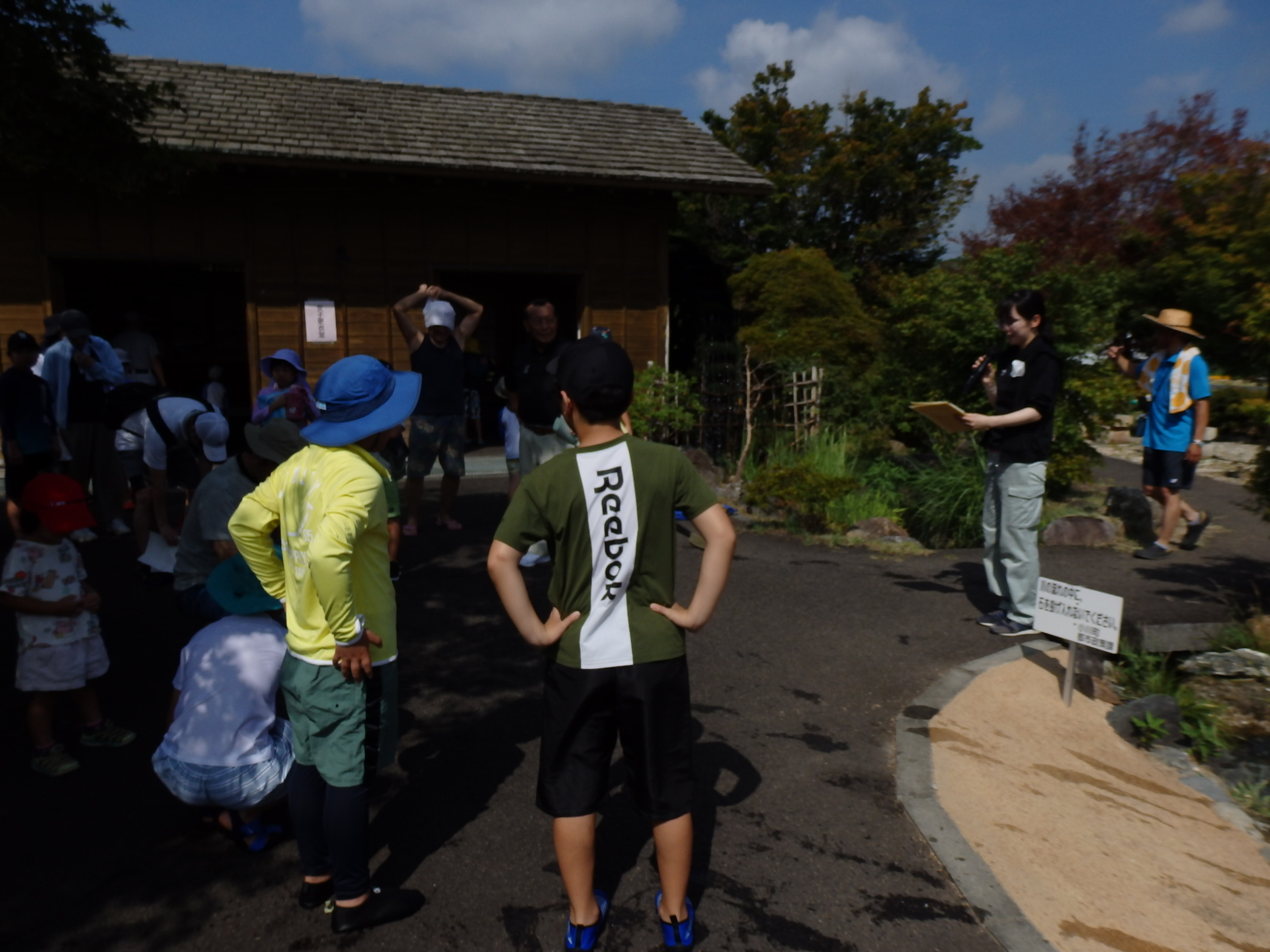 マイクを持ち話をしている女性の前に参加者達が集まっている写真