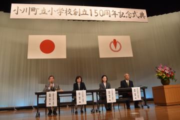 ステージ上のテーブルにつく4名の方々を撮影した写真