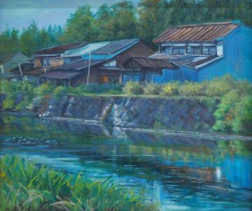 木々が生えた林の手前に民家が立ち並び、川の水面に反射している風景を川の手前側から描いた下平 史子さんの作品