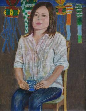 様々な形や色の七夕飾りが飾られ、背もたれがついた椅子に白いシャツとジーンズ姿の女性が青色の湯飲みを持っている様子を描いた中島 康夫さんの作品