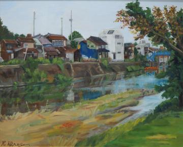 川沿いに立つ古民家や白色の壁の高い家が入り混じっている家並みを、川の向こう岸から描いた廣瀬 瑠莉子さんの作品