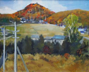 赤やオレンジ色に染まった山あいの麓に集落があり、田畑が広がっている風景を高台から描いた府瀬川 芙美恵さんの作品