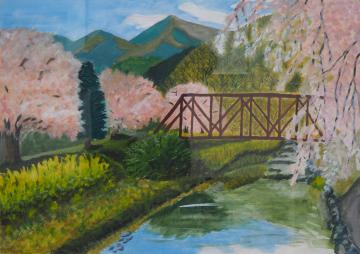 遠くに山並みが見え、橋がかかった川沿いにピンク色の花を咲かせた満開の桜が立っている様子が川の水面に反射している風景を描いた船戸 みのるさんの作品