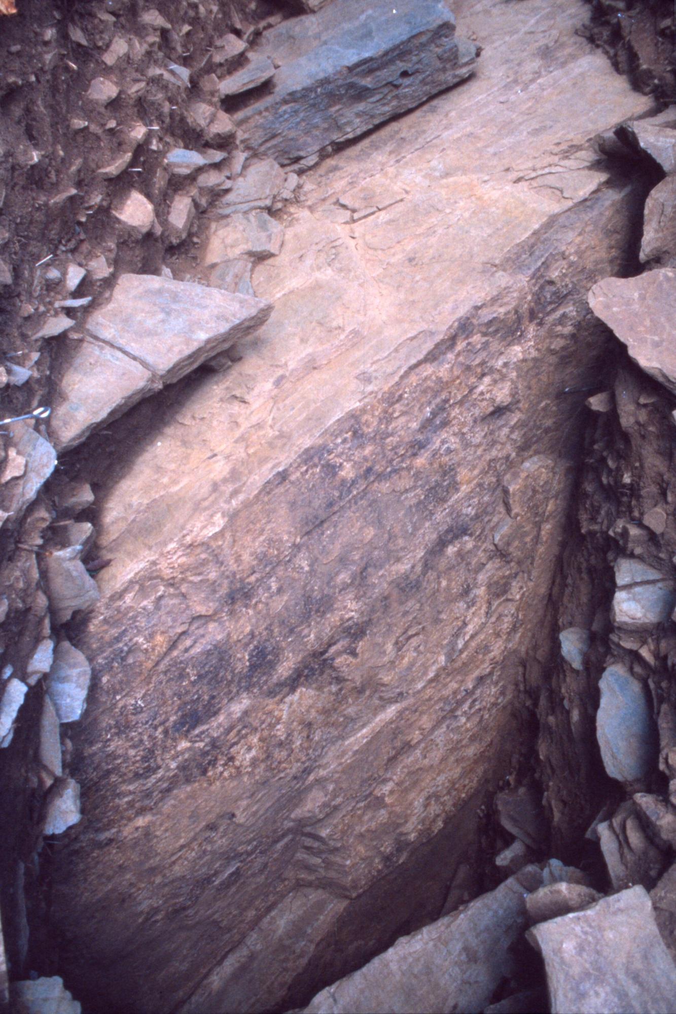 地層からたくさんの石板と大きな岩盤が検出されている写真