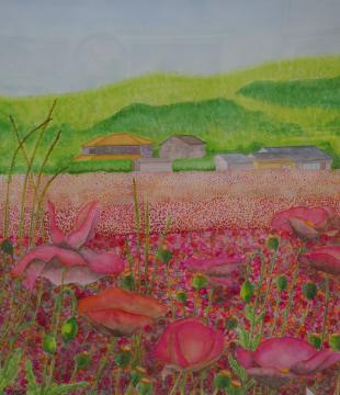小高い山の麓に民家が立ち、手前の原っぱに鮮やかなピンク色の花があたり一面に咲いている風景を描いた𠮷原 勉さんの作品