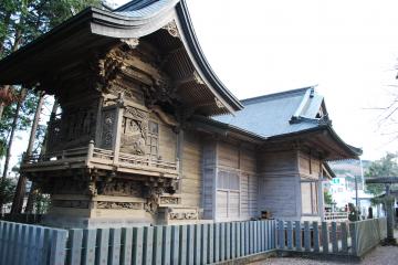 後方に木々がみえる入母屋造り、本瓦葺の八宮神社社殿の外観写真