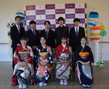 小川町のバックボードの前で前列に振袖姿の女性が4名が椅子に座り後列にスーツ姿の男性5名が立っている記念撮影の写真