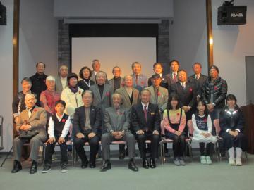 三列に並んだ受賞者の方々と一緒に一列目に座る松本町長との記念撮影の写真