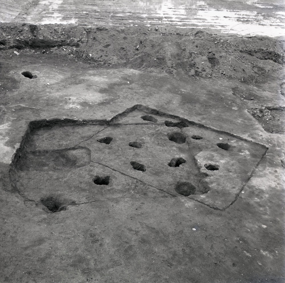 2つの四角の溝の一部が重なるように掘られており、内側には穴が数か所あいている住居跡の写真