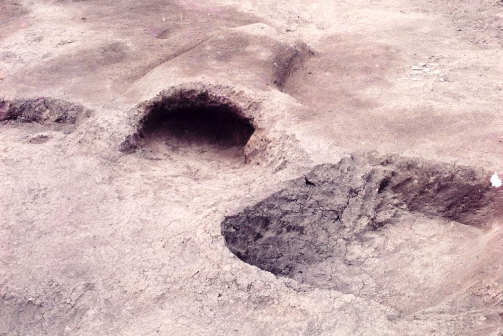 四角に掘られた貯蔵穴やトンネルのような穴があいた住居跡カマドの写真
