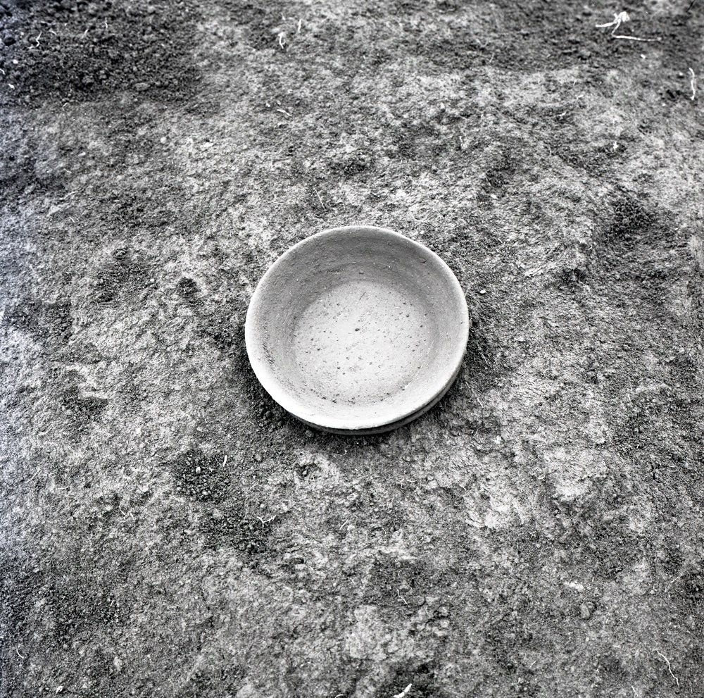 ヒビや欠けることなく出土された平皿のような形をした須恵器の写真