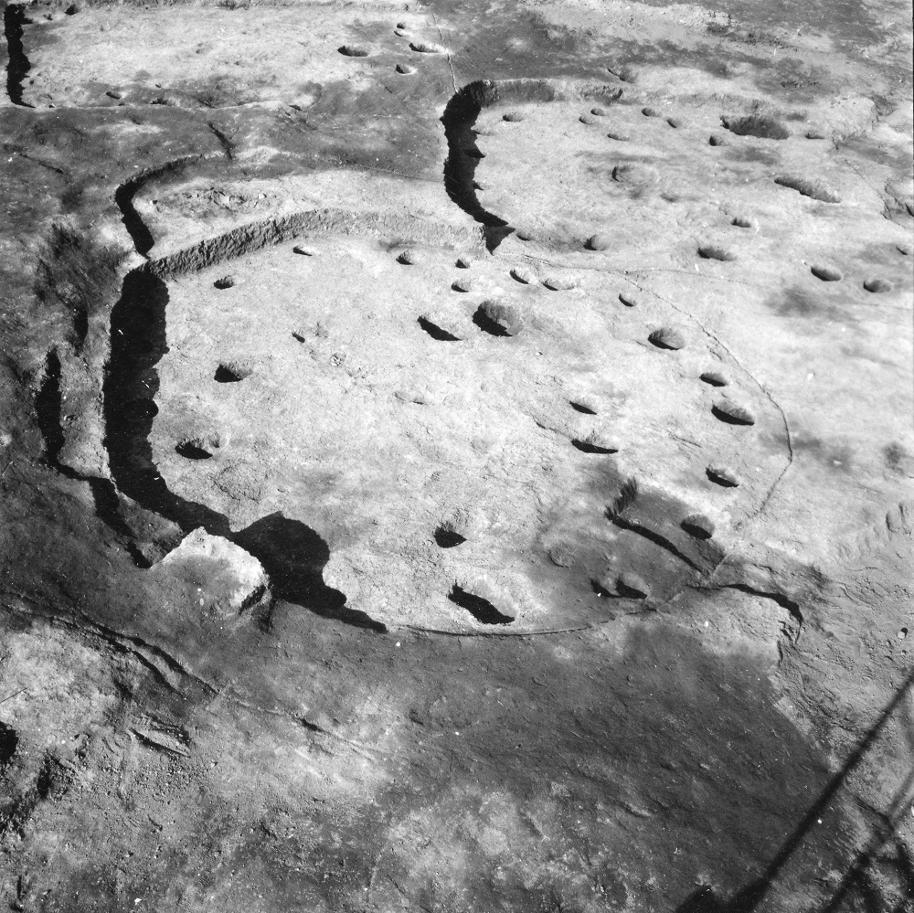 円状の掘られた2つの溝の中にそれぞれ石のようなものが複数おかれている住居跡の写真