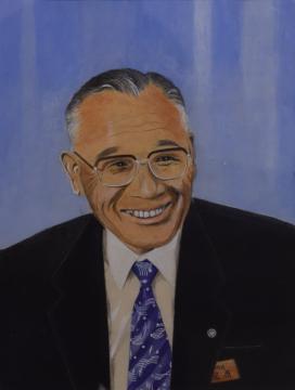 メガネをかけたスーツ姿の男性が笑っている関口 修さんの水彩画の写真