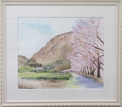 背景の山から続く細い小道の右側に並んで咲く桜の木が描かれた笠原 健さんの水彩画の写真