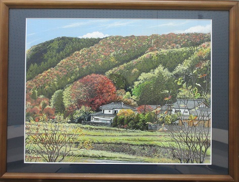 瓦屋根の家の背後の山々が赤や黄色に色づき始めた風景を描いた長谷部 紀一郎さんの水彩画の写真