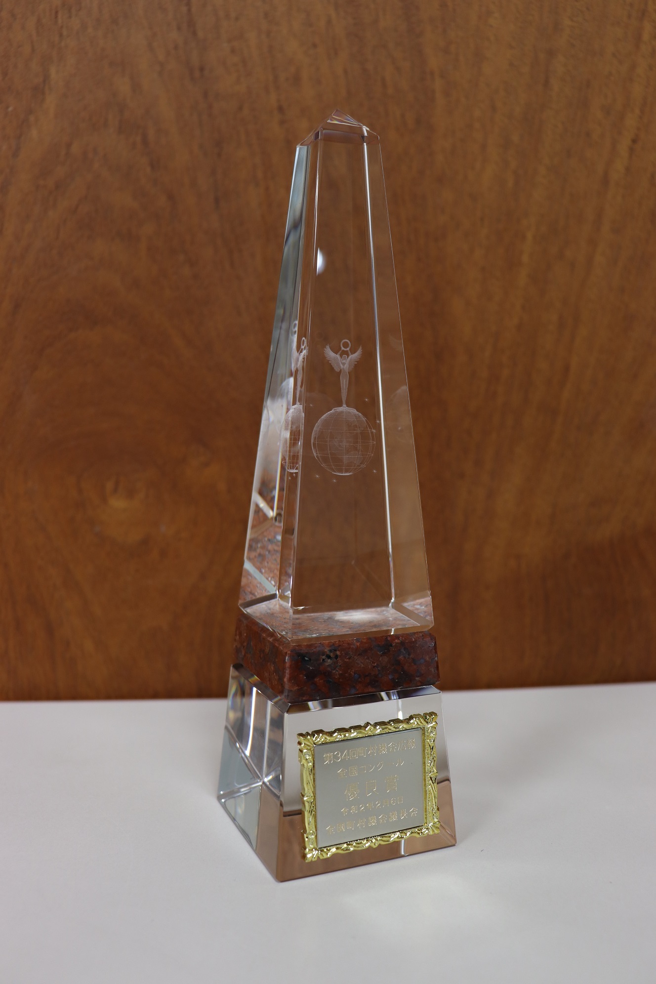 優良賞と刻印された長細い三角形の形をしたクリスタルのトロフィーの写真