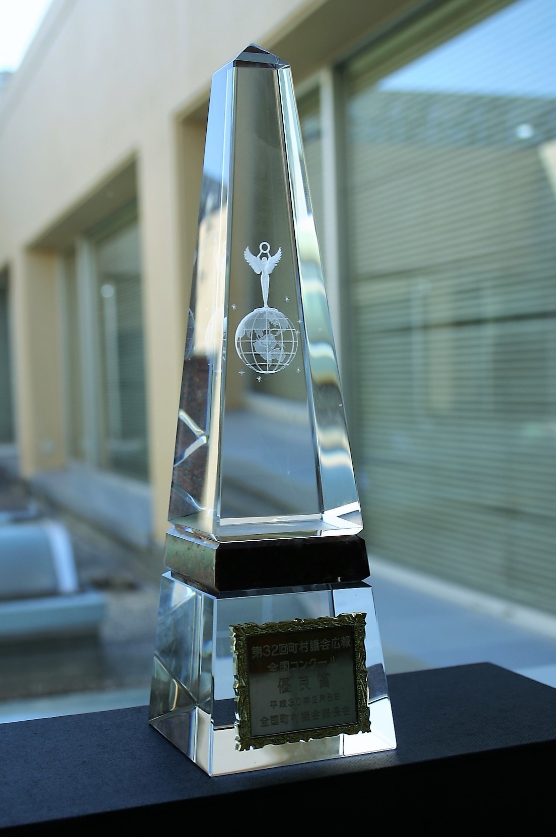 優良賞と刻印された長細い三角形の形をしたクリスタルのトロフィーの写真