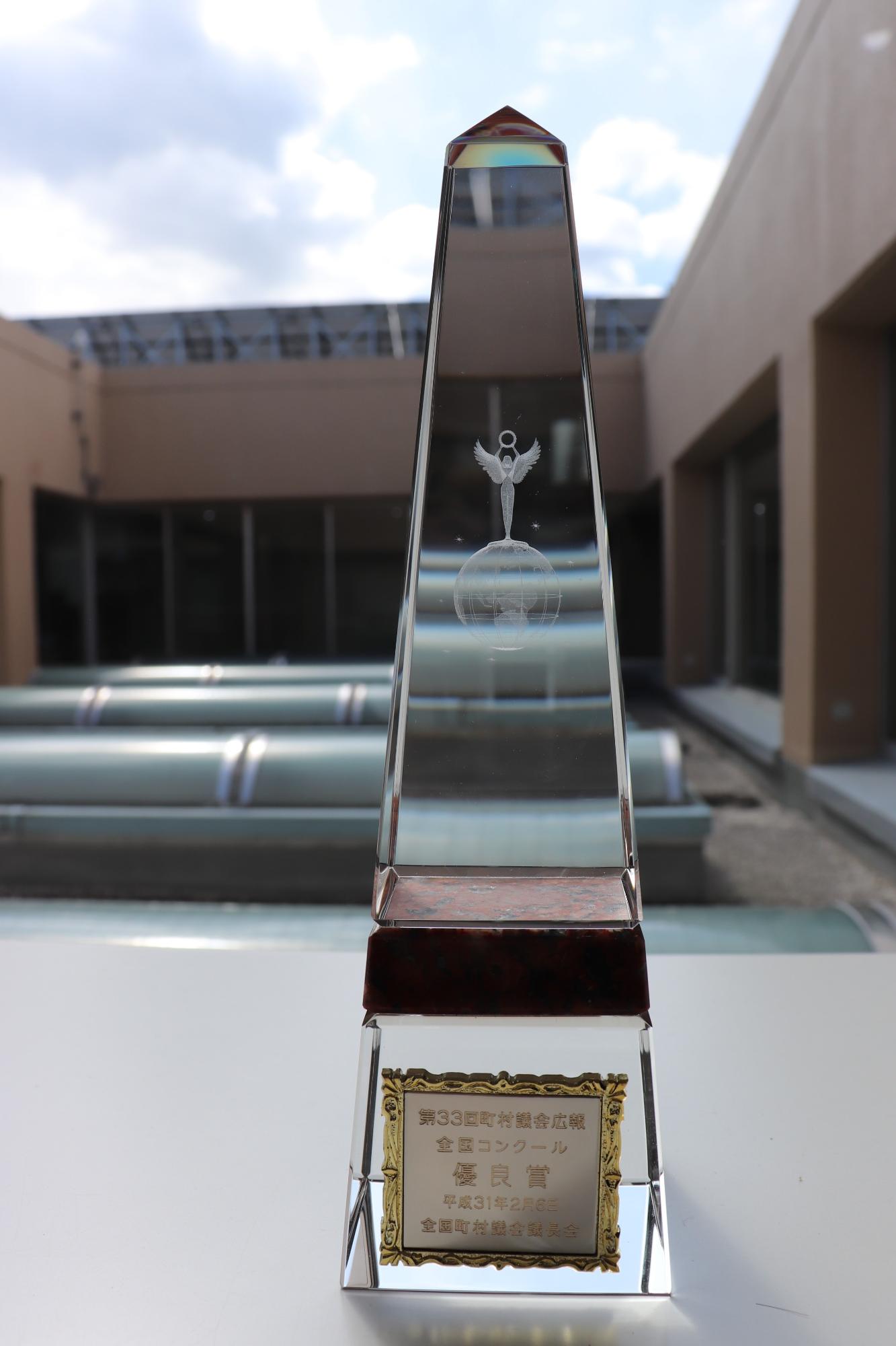優良賞と刻印された長細い三角形の形をしたクリスタルのトロフィーが窓際に置かれている写真