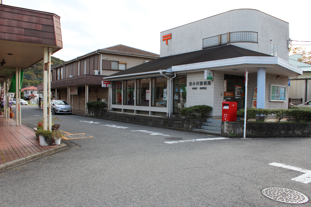 通りの角に建つ白い外観の東小川郵便局をななめ前から撮影した写真