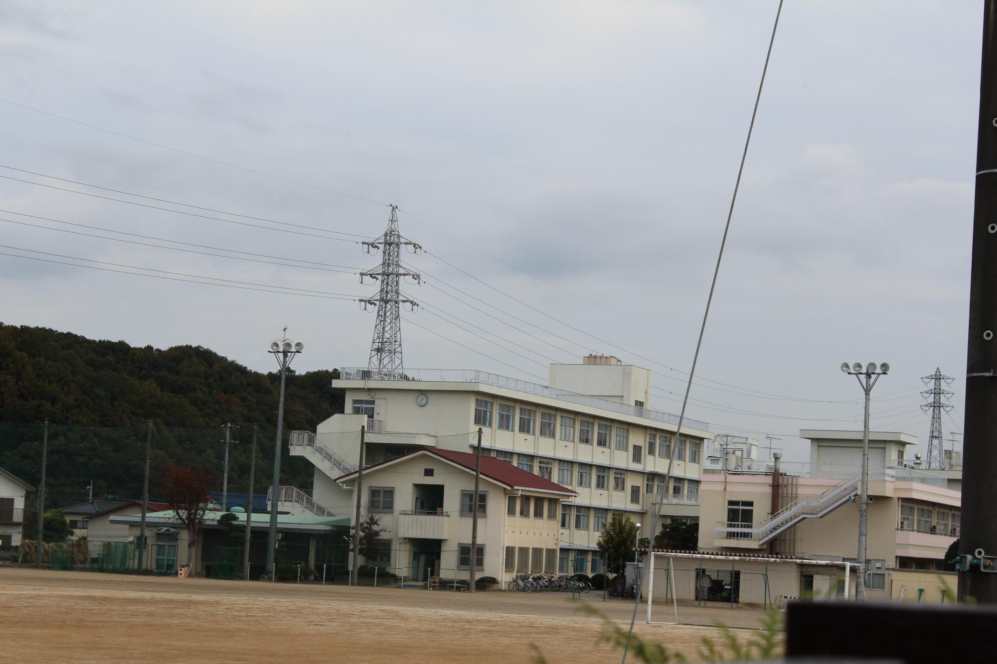 グランドの奥に白い外観の3階建て埼玉県立小川高等学校の写真