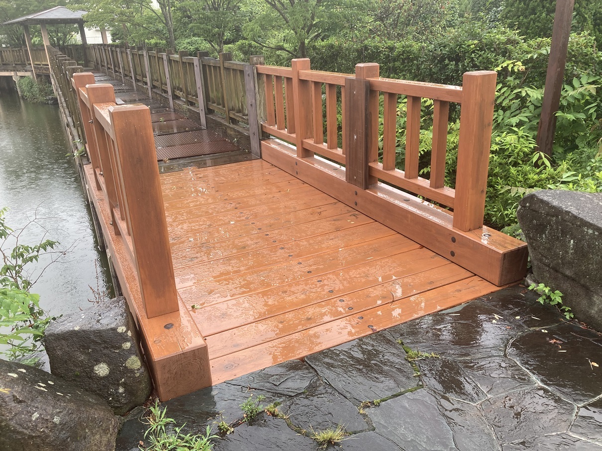 公園の池の上を渡る木橋のフェンスが設置された改修工事後の写真