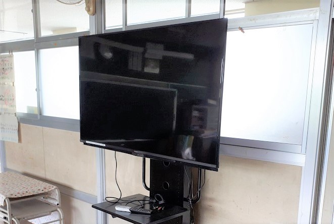 廊下の近くの教室内に設置された大型モニターの写真