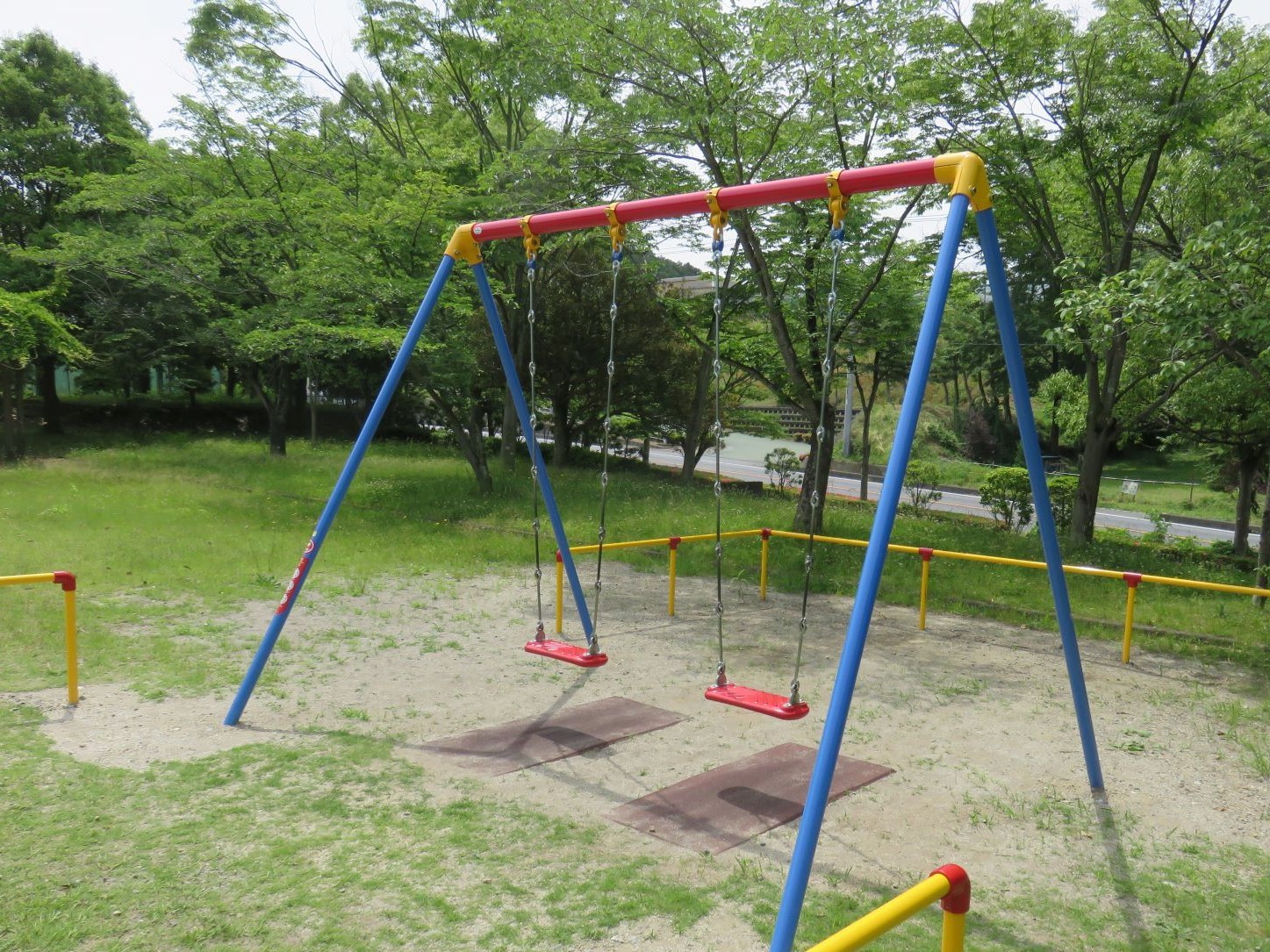 青や赤色で塗装された新しいブランコの写真