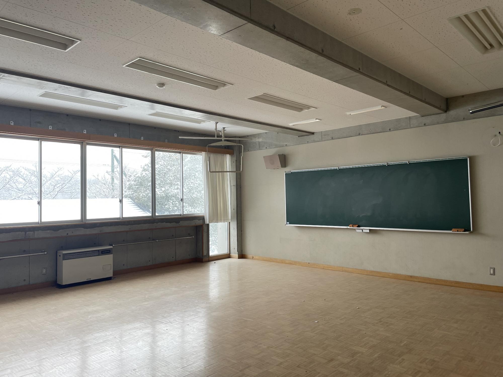 室内前方に黒板が設置された教室内の写真