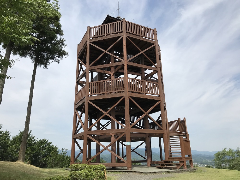 高台に設置された木製の3階建ての展望台の写真