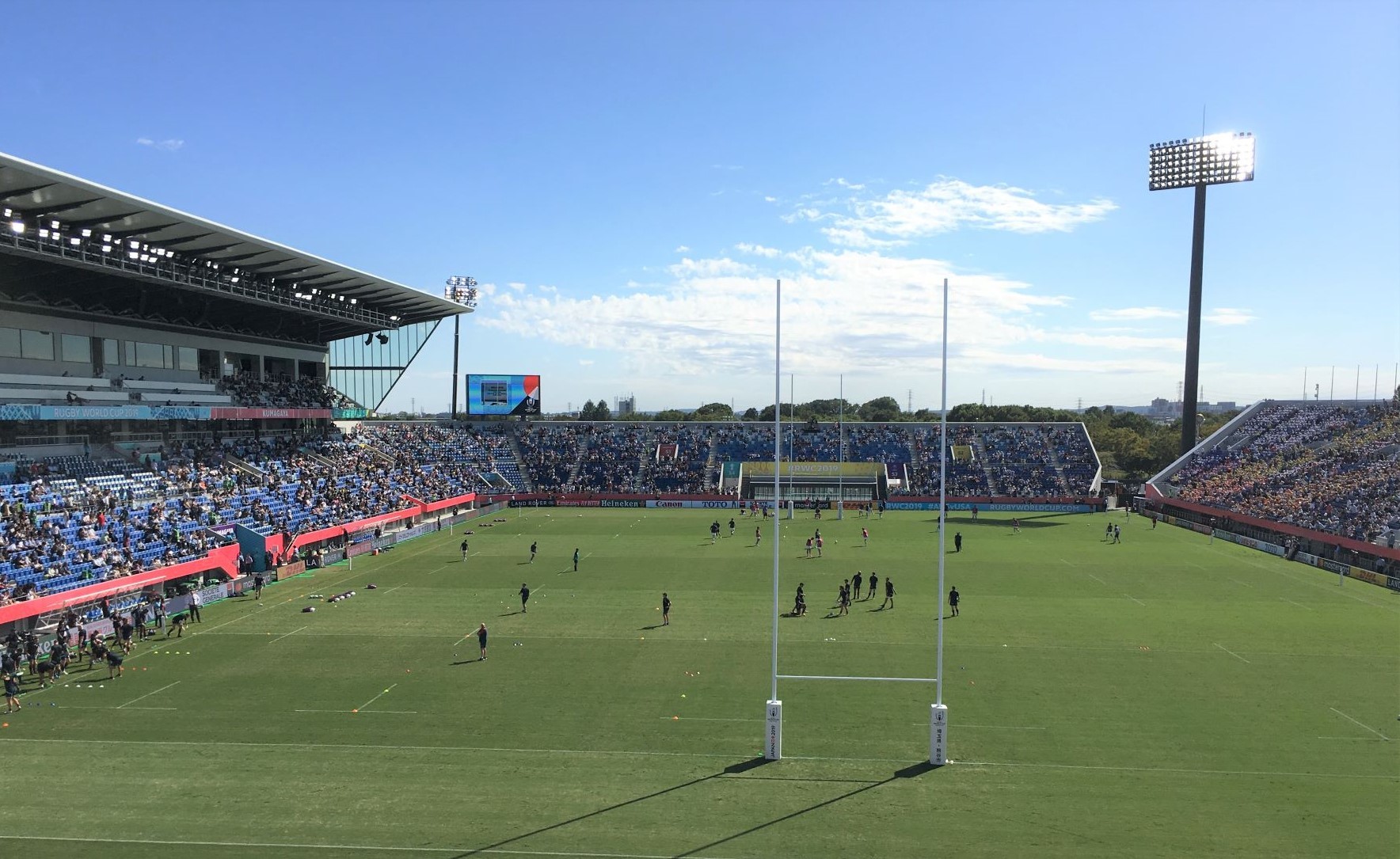 大勢の観客が観戦している大きな会場でラグビーの試合が行われている写真