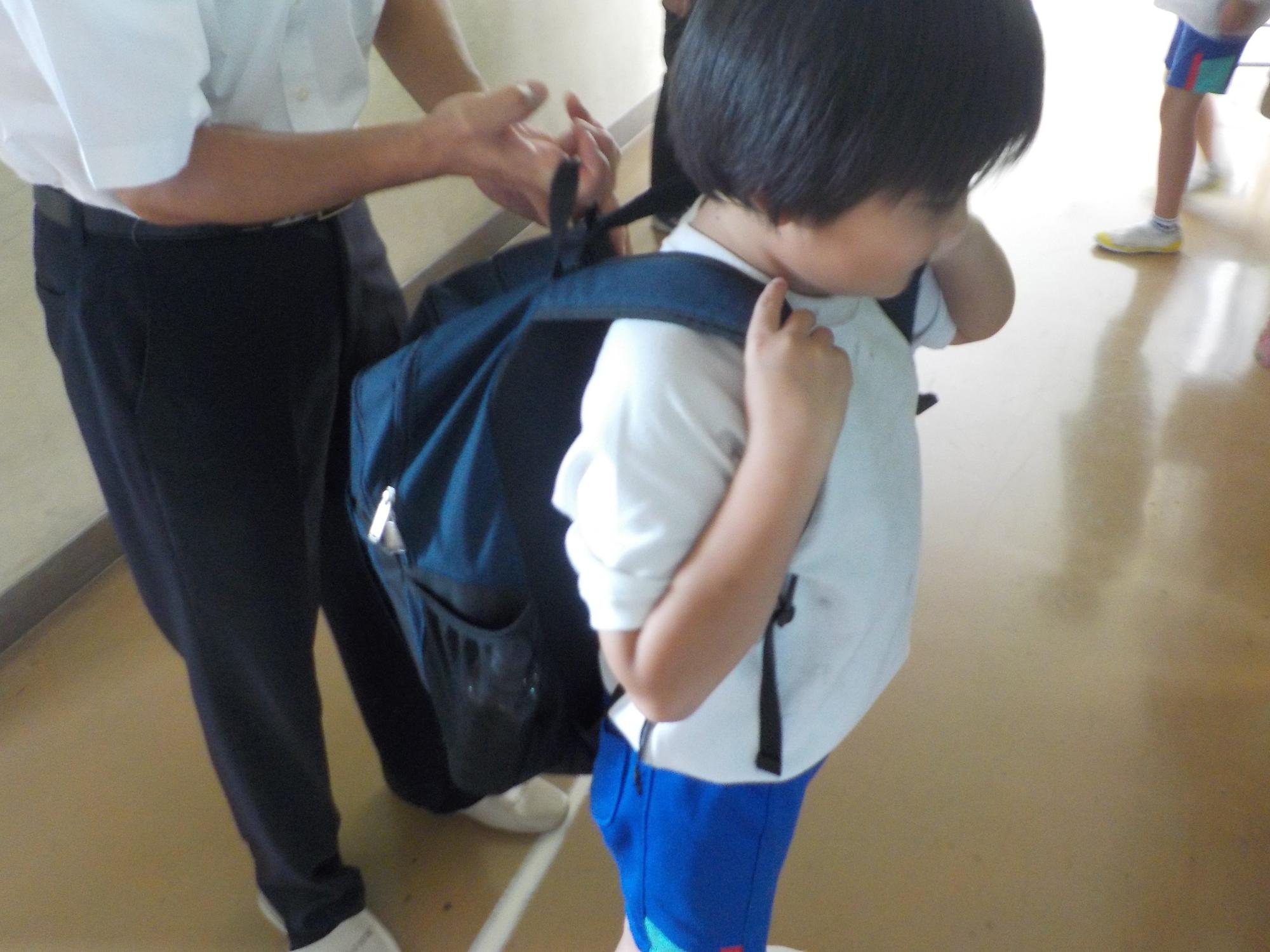 1人の児童が紺色の防災リュックを背負っている写真