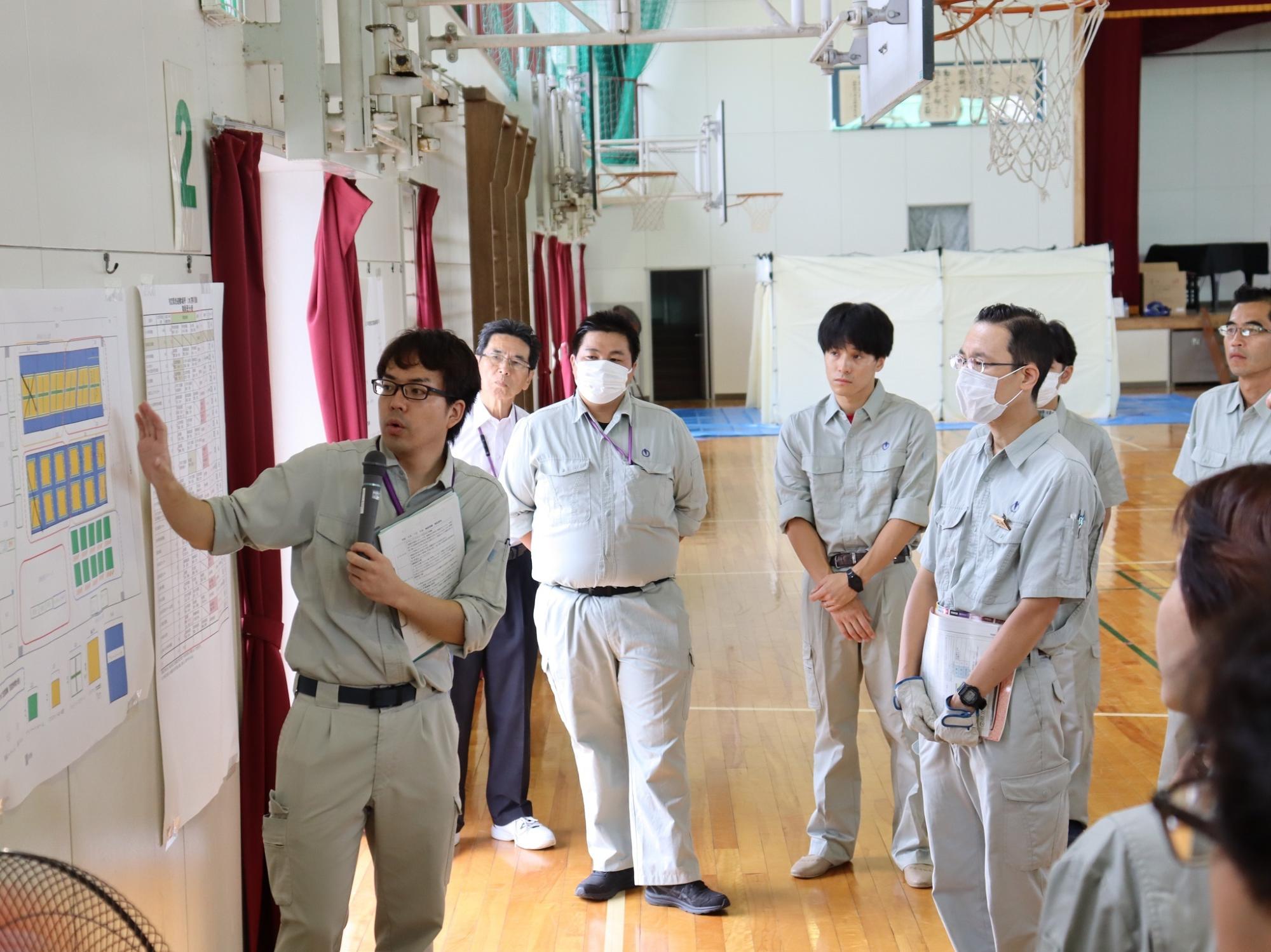 男性が資機材の展開順番などを参加者たちに説明している写真