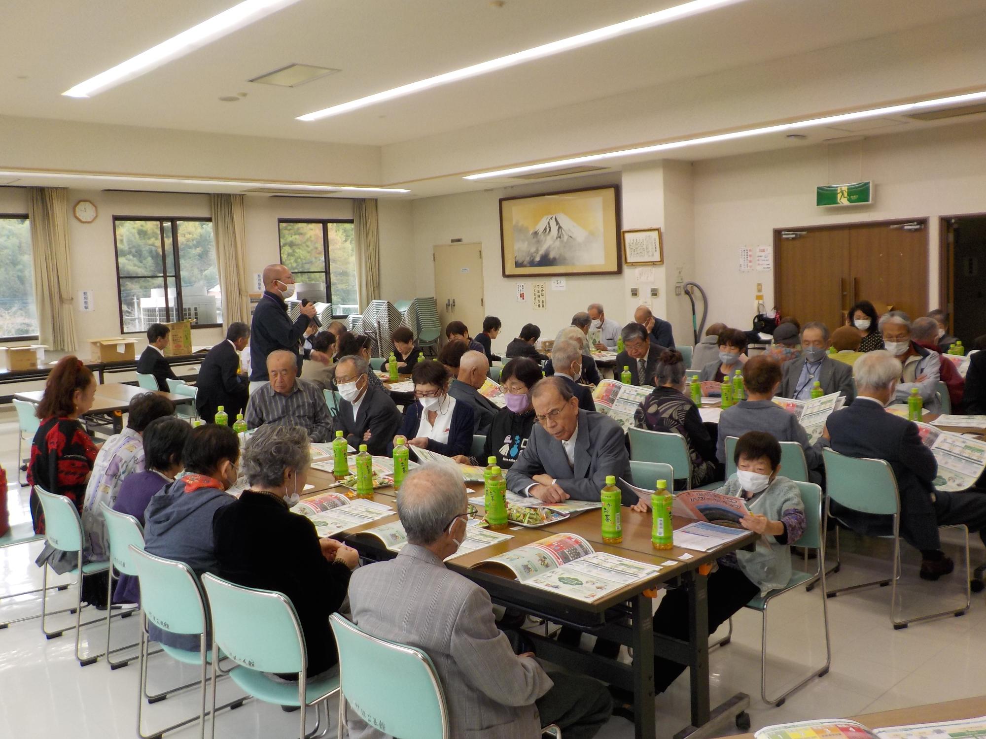 広い部屋の中で大勢の参加者たちが防災講座を受けている写真