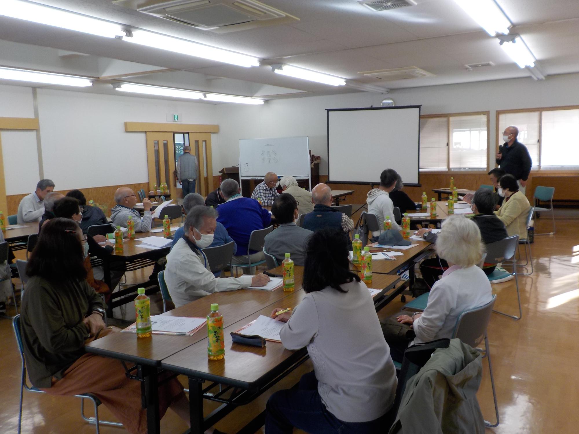 参加者たちが部屋の中で長机の前の椅子に座りながら防災講座を受けている写真