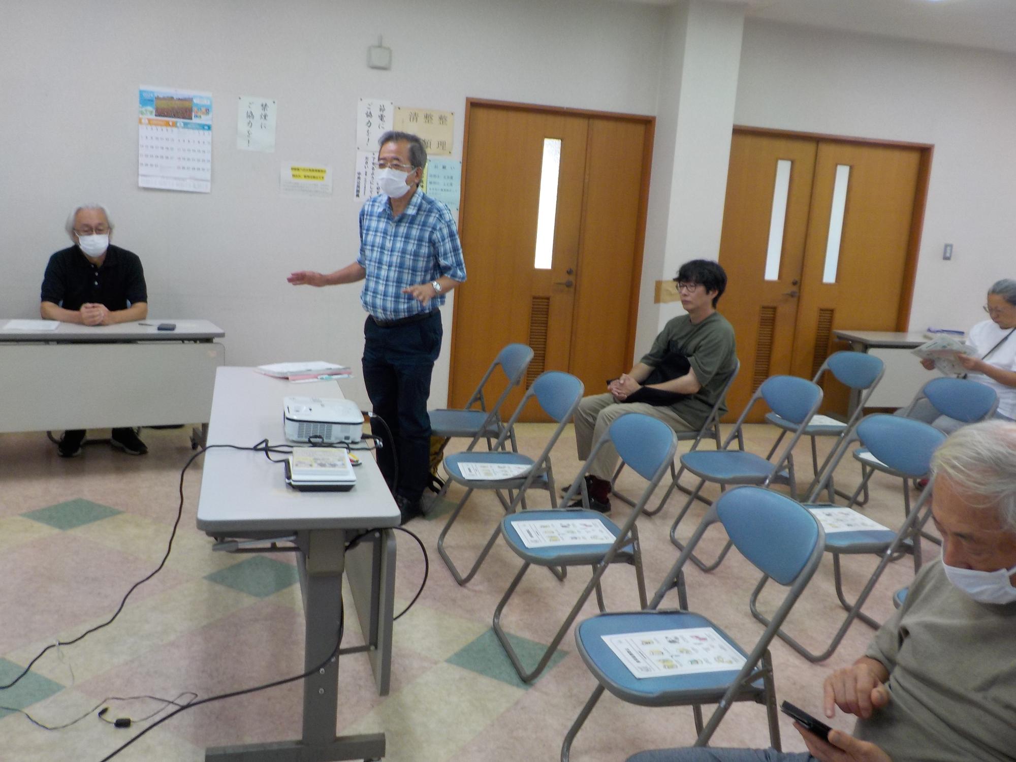 身振り手振りをつけながら質疑応答に答える区長の様子を撮影した写真