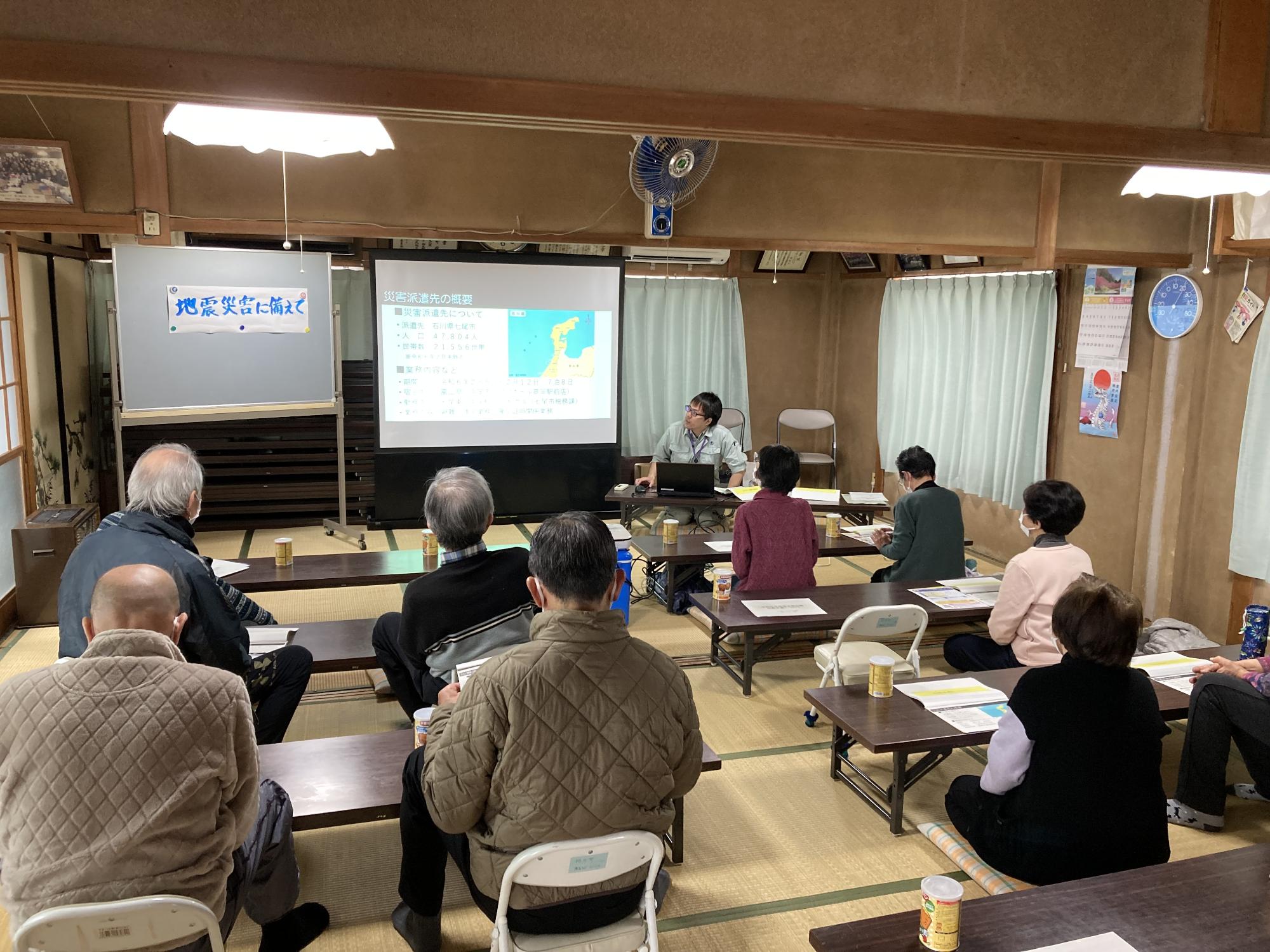 前方のスクリーンに映し出された資料の説明を熱心に聞いている参加者の方々を後方から撮影した写真